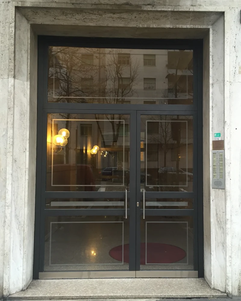 Nuovo portone ingresso due ante con sopraluce e vetri fumè installato a Milano